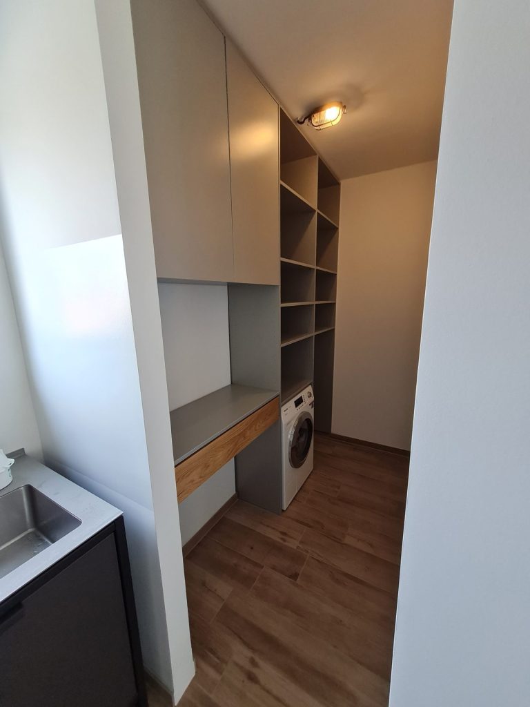 Ein eleganter begehbarer Kleiderschrank mit großem Spiegel, der einen übersichtlichen Raum voller modischer Kleidung und Accessoires hervorhebt.