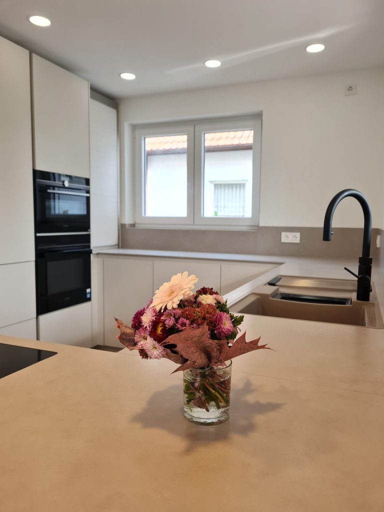 Eine Vase voller bunter Blumen steht elegant auf einer Küchentheke.