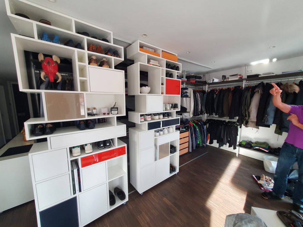 Ein Mann befindet sich in einer gut beleuchteten Küche und ist mit dem Kochen beschäftigt; um ihn herum sind verschiedene Utensilien und Zutaten zu sehen.