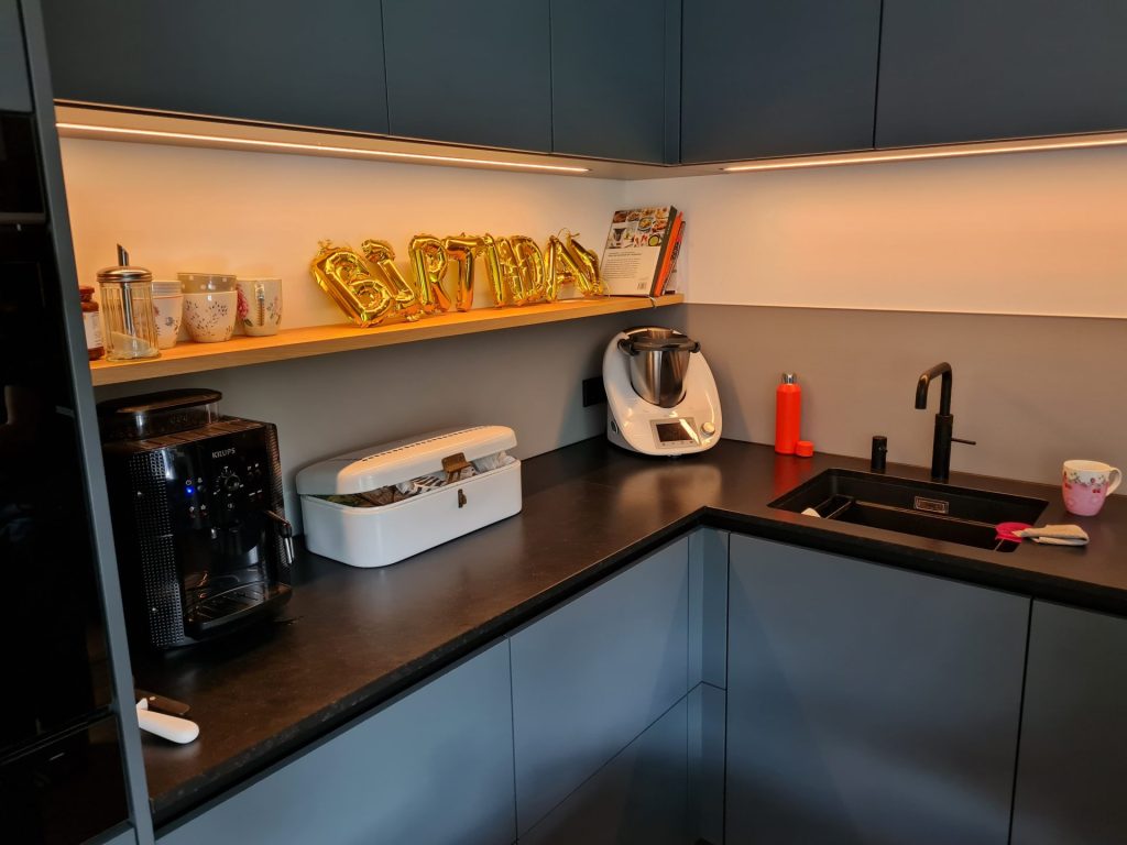 Eine Küche mit Spüle, Mikrowelle und Kaffeemaschine, die für den funktionalen Gebrauch angeordnet sind.