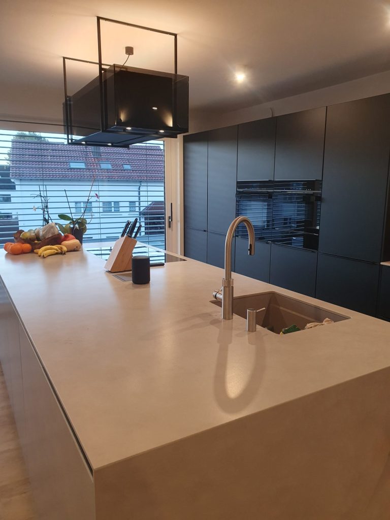 Eine stilvolle Küche mit eleganten weißen Schränken und edlem Holzboden, die ein modernes und gemütliches Design bietet.